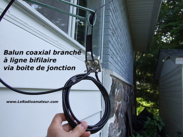 Boite de jonction reliant une ligne d'alimentation bifilaire et un câble coaxial servant à protéger les connexions des intempéries. Vue de la boite installée à l'extérieur.
